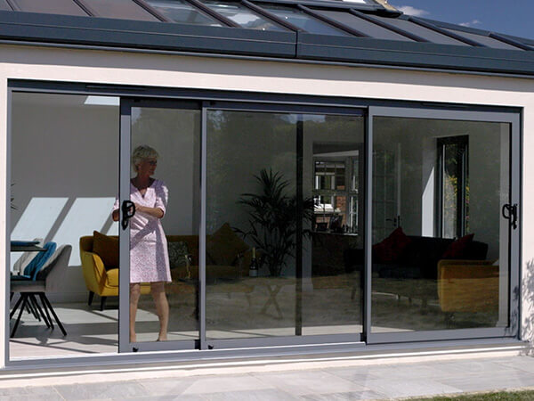 A lady opening her patio doors